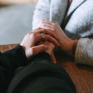 Two people holding hands in comfort