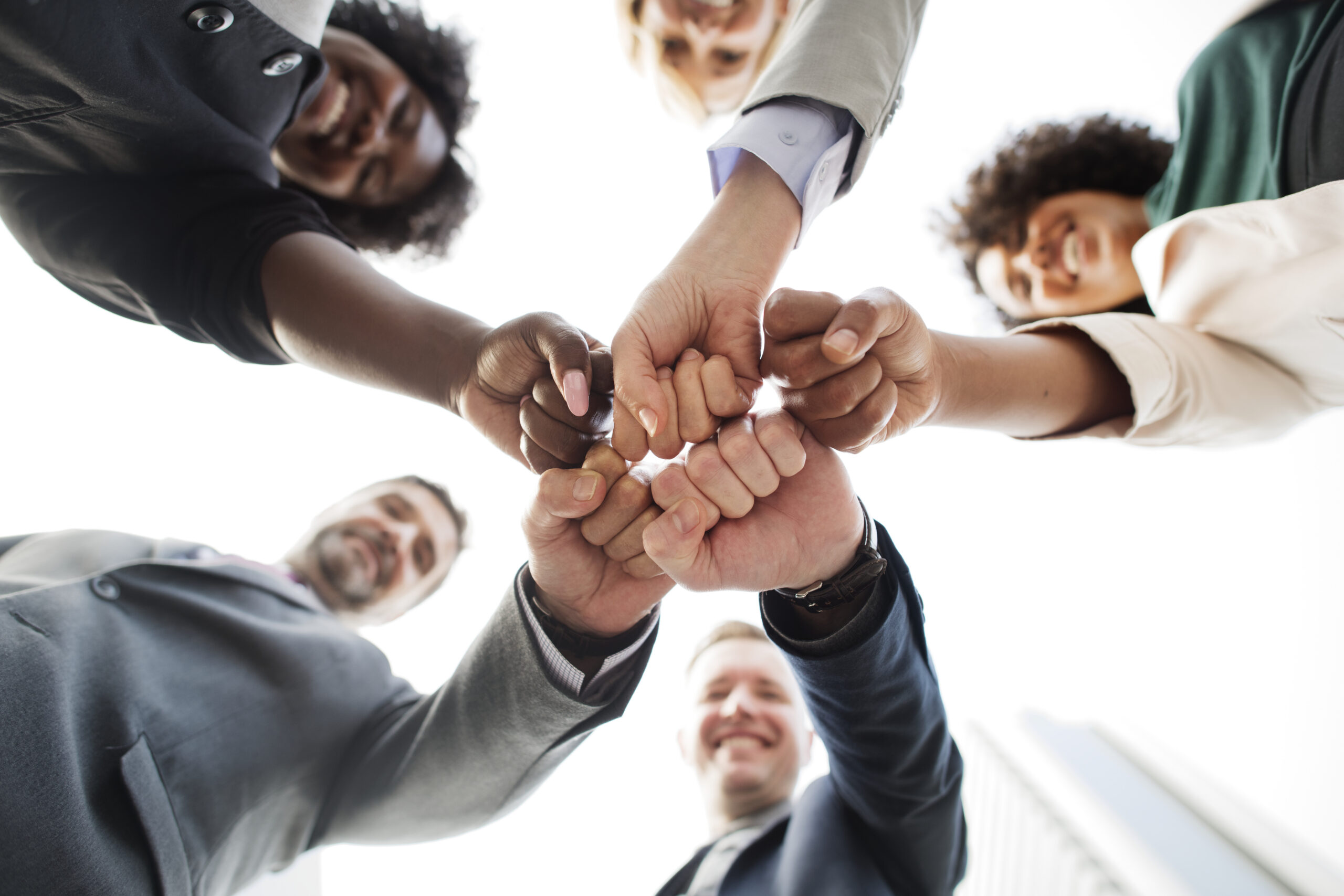 Diverse group joining their fists together in a show of unity and support.